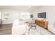 Bright living room with modern furniture, wood floors, and large windows for natural light at 272 Johnson Ridge Way, Four Oaks, NC 27524