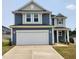 Two-story home featuring a two-car garage, blue siding, and a well-manicured lawn at 28 Longdale Dr, Graham, NC 27253