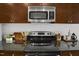Close-up of a kitchen with stainless steel oven, dark cabinets and granite countertops at 301 Fayetteville St # 3205, Raleigh, NC 27601
