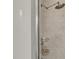 Shower with brushed metal shower head, textured tile, and corner shelving for toiletries at 301 Fayetteville St # 3205, Raleigh, NC 27601
