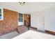 Brick back porch with white accents has an entry door and outdoor space for relaxing at 307 S Main St, Four Oaks, NC 27524