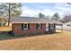 Well-maintained brick house with a dark roof and manicured lawn offering great curb appeal at 307 S Main St, Four Oaks, NC 27524