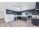Well-lit kitchen featuring blue cabinets, stainless steel appliances, and durable countertops at 307 S Main St, Four Oaks, NC 27524