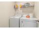 Laundry room boasts a washer and dryer set, with shelving for organized storage of laundry supplies at 310 Mineral Spring Ln, Fuquay Varina, NC 27526