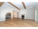 Spacious living room boasts hardwood floors, wooden ceiling beams, and a modern wine storage and fireplace at 4225 Burlington Mills Rd, Wake Forest, NC 27587