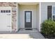 Inviting front entry with a glass-paneled door, stone accents, and well-manicured landscaping at 425 Legacy Dr, Youngsville, NC 27596