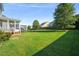 Expansive backyard with lush lawn, mature trees, and a screen porch, perfect for outdoor activities at 4508 Brintons Cottage St, Raleigh, NC 27616