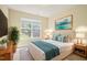Bright bedroom featuring neutral walls, queen bed with stylish blue pillows, and natural light at 4508 Brintons Cottage St, Raleigh, NC 27616