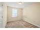 Neutral bedroom featuring a carpeted floor, beige walls, and a window allowing natural light at 4508 Brintons Cottage St, Raleigh, NC 27616