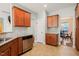 Cozy kitchen featuring wood cabinets, granite countertops, stainless steel dishwasher, and tiled backsplash at 4508 Brintons Cottage St, Raleigh, NC 27616