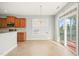 Open kitchen nook with wood cabinets, granite countertops, tile backsplash, sliding door to patio at 4508 Brintons Cottage St, Raleigh, NC 27616