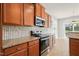 Modern kitchen with stainless steel appliances, granite countertops, and stylish tile backsplash at 4508 Brintons Cottage St, Raleigh, NC 27616