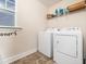 Laundry room featuring a washer, a dryer, tile floors, and shelving at 4508 Brintons Cottage St, Raleigh, NC 27616