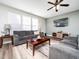 Cozy living room with a ceiling fan, wood floors and large windows at 4508 Brintons Cottage St, Raleigh, NC 27616