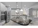 Modern kitchen featuring stainless appliances, stone countertops and large island with pendant lights at 47 Dover Grant Ct, Chapel Hill, NC 27517