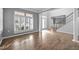 Sunlit living room features hardwood floors, large windows, and entrance to the foyer at 47 Dover Grant Ct, Chapel Hill, NC 27517