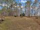 Spacious backyard with lush green trees, lawn and a deck extending from the house at 5661 Quail Covey Ln, Wendell, NC 27591