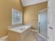 Bright bathroom featuring a soaking tub, glass enclosed shower, and tiled flooring at 5661 Quail Covey Ln, Wendell, NC 27591