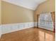 Spacious bedroom features hardwood floors and large window with custom curtains at 5661 Quail Covey Ln, Wendell, NC 27591