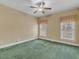 This bedroom features two windows with decorative curtains, and neutral carpet at 5661 Quail Covey Ln, Wendell, NC 27591