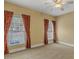 Bedroom with neutral carpet, windows with red-patterned curtains, and a ceiling fan at 5661 Quail Covey Ln, Wendell, NC 27591