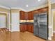 Kitchen with stainless steel fridge, wooden cabinets, and tiled floors at 5661 Quail Covey Ln, Wendell, NC 27591