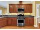Kitchen featuring granite countertops, stainless steel appliances, and wooden cabinets at 5661 Quail Covey Ln, Wendell, NC 27591