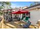 Cozy deck area with comfortable seating and a vibrant red umbrella for shade at 573 Broadmoor Ct, Sanford, NC 27332