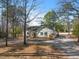 Ranch-style home with an attached two-car garage nestled among tall trees at 573 Broadmoor Ct, Sanford, NC 27332