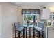Eat-in kitchen features a glass table and chairs near a sunlit window with a decorative valance at 573 Broadmoor Ct, Sanford, NC 27332