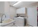 Functional laundry room with a sink, cabinets, washer, dryer, and direct access to the garage at 573 Broadmoor Ct, Sanford, NC 27332