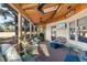 Relaxing screened-in porch with ceiling fans, comfortable furniture, and a view of the lush backyard at 573 Broadmoor Ct, Sanford, NC 27332