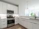 Open concept kitchen with stainless appliances, quartz counters and modern white cabinets at 620 Walnut Hts Dr # 104, Raleigh, NC 27610