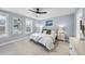 This bedroom features neutral walls, a ceiling fan, two bedside tables with lamps, and a view out of the window at 656 Groveview Wynd, Wendell, NC 27591