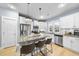 Bright kitchen featuring a center island with seating, stainless steel appliances, and white cabinetry at 656 Groveview Wynd, Wendell, NC 27591