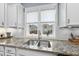Close up of a stainless steel kitchen sink with granite countertops and a view to backyard at 656 Groveview Wynd, Wendell, NC 27591