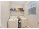 Efficient laundry area with a washer and dryer, plus overhead shelving for storage at 702 Great Eno Path, Hillsborough, NC 27278