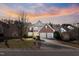 Charming two-story brick home featuring a well-manicured lawn and a two-car garage at sunset at 715 Southshore Pkwy, Durham, NC 27703