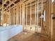 Unfinished bathroom featuring exposed studs and a modern white tub ready for finishing at 7429 Wexford Woods Ln, Wake Forest, NC 27587