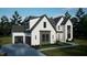 New construction home with light grey brick, white siding with grey accents and black window frames and a garage at 7429 Wexford Woods Ln, Wake Forest, NC 27587