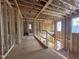 Unfinished second-story hallway with exposed studs, plywood flooring and a view to the outside through window frames at 7429 Wexford Woods Ln, Wake Forest, NC 27587