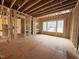 Unfinished interior showcasing wood framing, large windows, and an open layout ready for customization at 7429 Wexford Woods Ln, Wake Forest, NC 27587