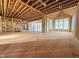Spacious open concept living area under construction with exposed wood framework and large windows at 7429 Wexford Woods Ln, Wake Forest, NC 27587