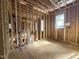 Unfinished room featuring exposed rafters, plywood flooring and multiple window frames for natural light at 7429 Wexford Woods Ln, Wake Forest, NC 27587