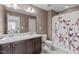 Bathroom with a double sink vanity, toilet, and shower with a floral curtain at 749 Lake Artesia Ln, Fuquay Varina, NC 27526