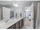 Elegant bathroom showcasing double sinks, wood cabinets, and a view into the adjoining bedroom at 749 Lake Artesia Ln, Fuquay Varina, NC 27526
