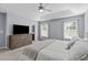 Inviting bedroom with a tray ceiling, soft blue walls, neutral carpet, and a matching dresser and TV at 749 Lake Artesia Ln, Fuquay Varina, NC 27526