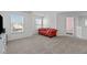 Relaxing bonus room with neutral carpet and a red sofa near the windows, offering plenty of space at 749 Lake Artesia Ln, Fuquay Varina, NC 27526