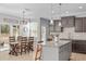 Well-lit kitchen with granite countertops, stainless steel sink, dark cabinetry, and an island with bar stool seating at 749 Lake Artesia Ln, Fuquay Varina, NC 27526
