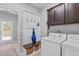 Convenient mudroom featuring coat hooks, a bench with storage baskets, and a nearby washer and dryer at 749 Lake Artesia Ln, Fuquay Varina, NC 27526